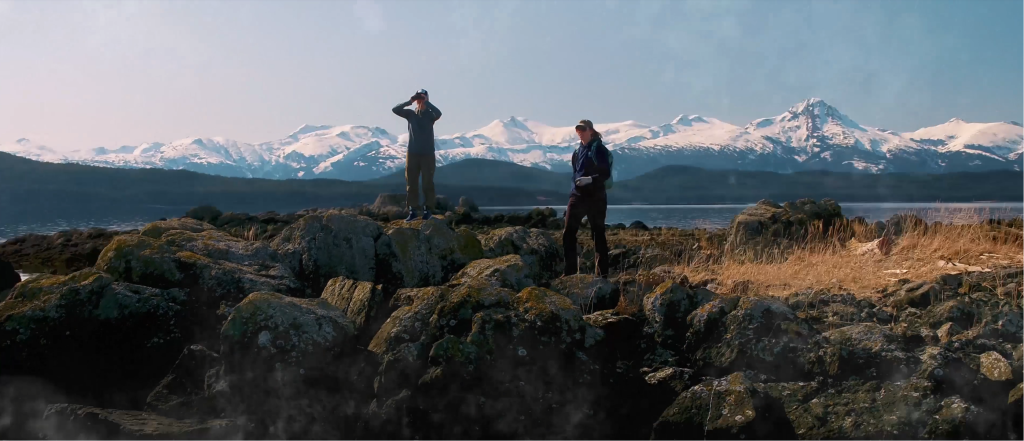 Two hikers with snow covered mountains in background for University of Alaska Fairbanks video by Stage 2 Studios